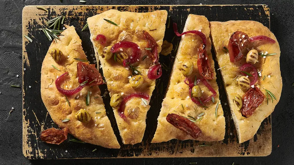 Focaccia med grillede oliven, soltørrede tomater og syltede rødløg